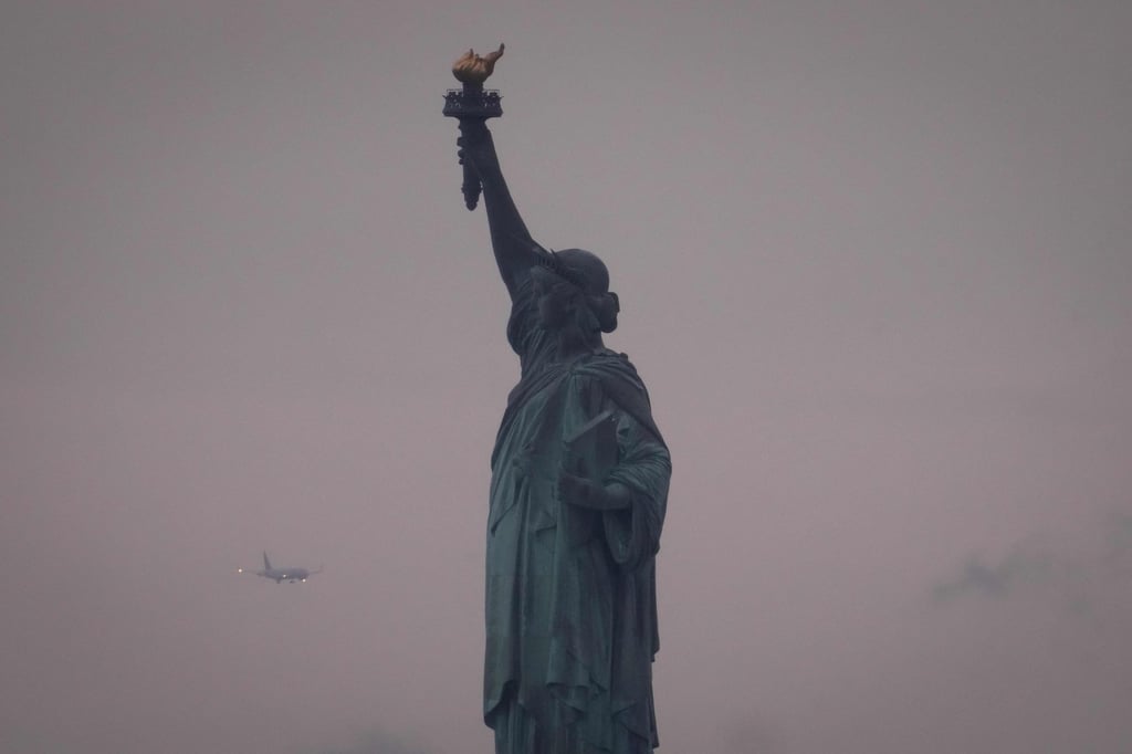 A plane prepares to land at Newark Liberty International Airport behind the Statue of Liberty in June. Photo: AFP A plane prepares to land at Newark Liberty International Airport behind the Statue of Liberty in June. Photo: AFP