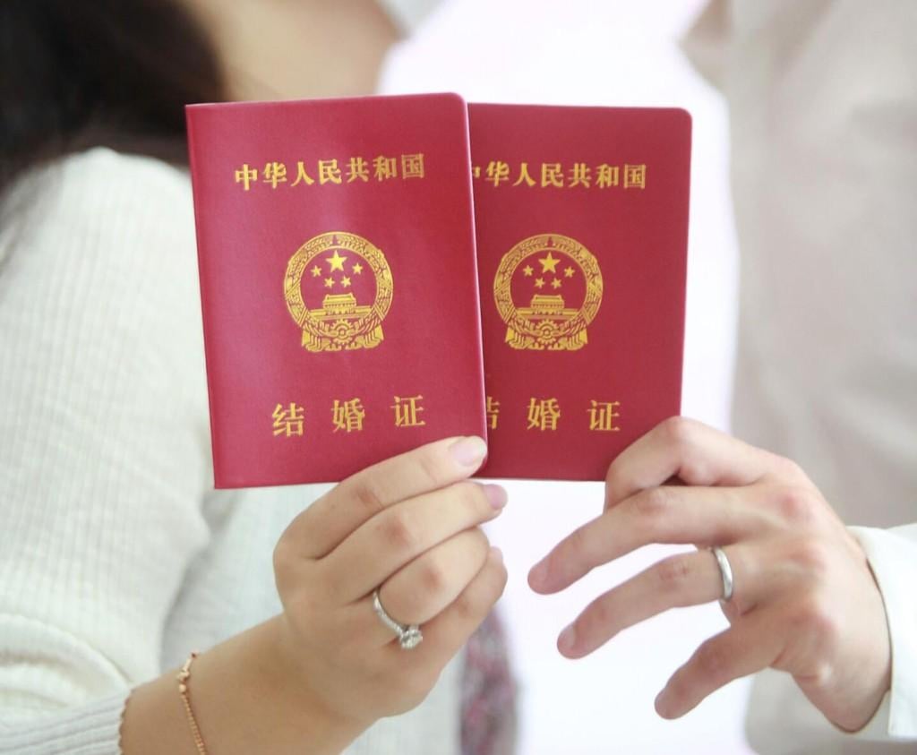 A pair of marriage passbooks. One of the fines listed was for couples living together before they wed. Photo: Xinhua