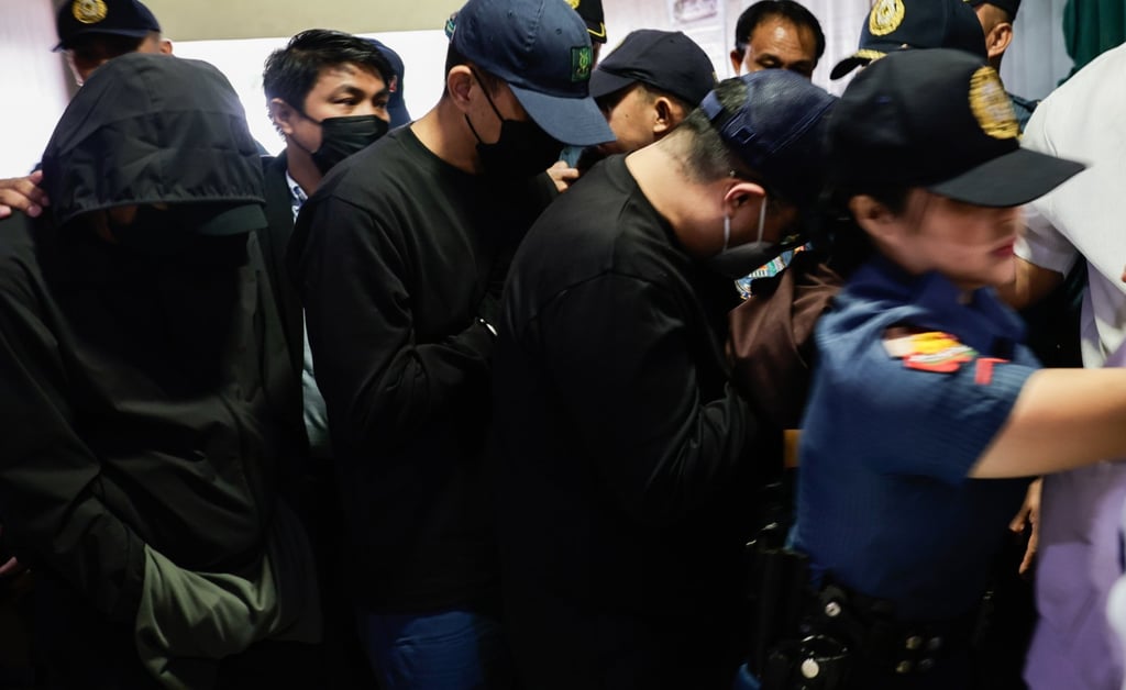Arrested officials from the Philippine Department of Public Works and Highways are escorted by police to an anti-corruption court in Quezon City on November 24. Photo: EPA.