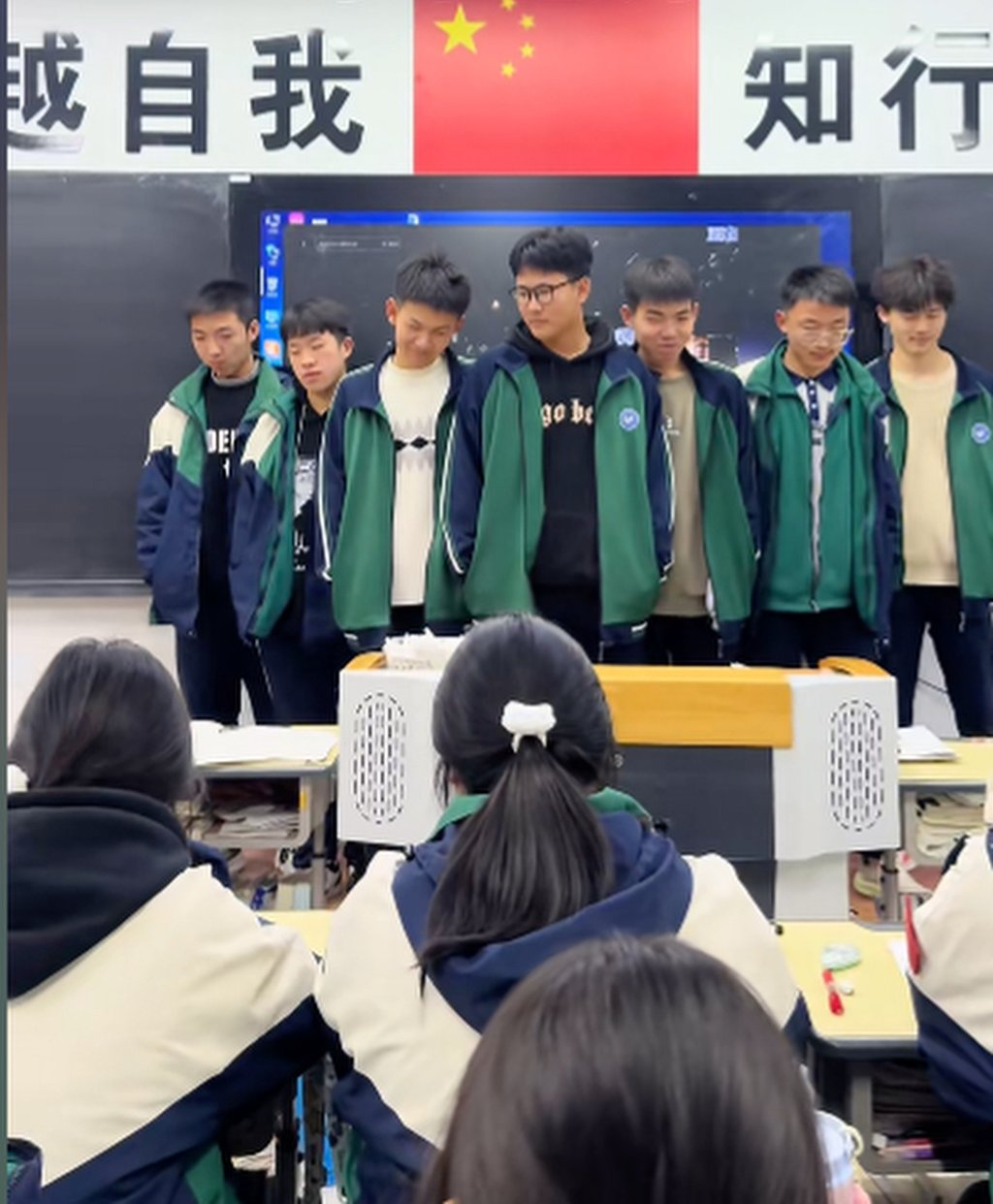 The tardy boys get ready to perform on the podium as their classmates look on. Photo: Douyin