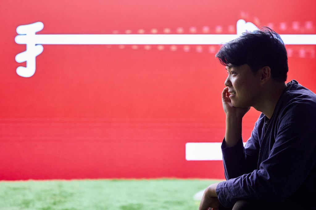 Wong Ping is photographed in front of his work Debts in the Wind. Photo: M+