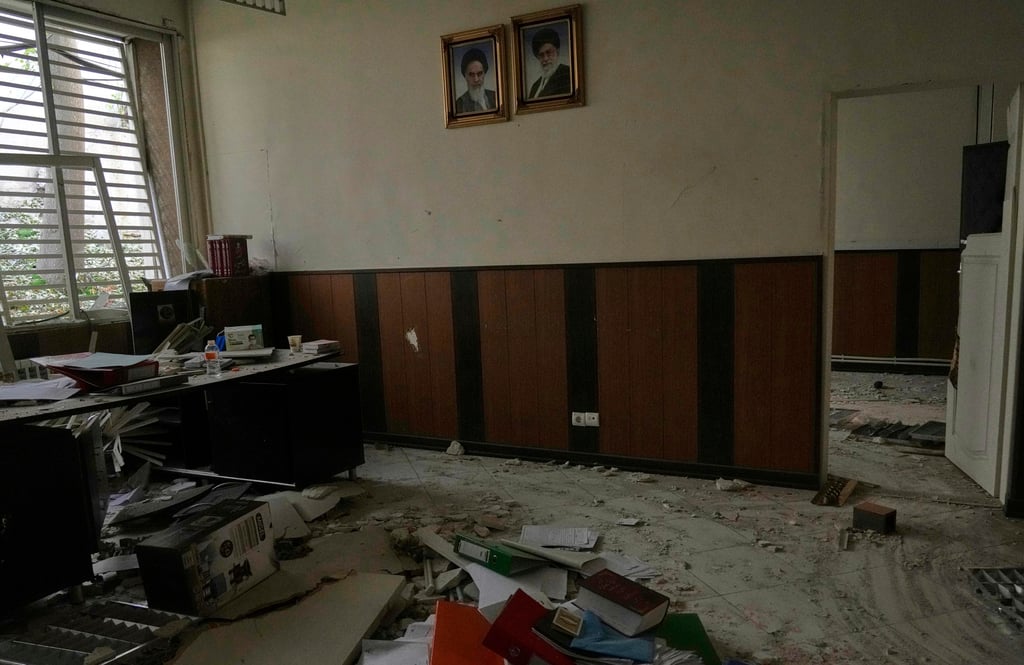 Portraits of the late Iranian revolutionary founder Ayatollah Khomeini (left) and Supreme Leader Ayatollah Ali Khamenei hang on the wall of a building that was damaged by an Israeli air strike on June 29. Photo: AP