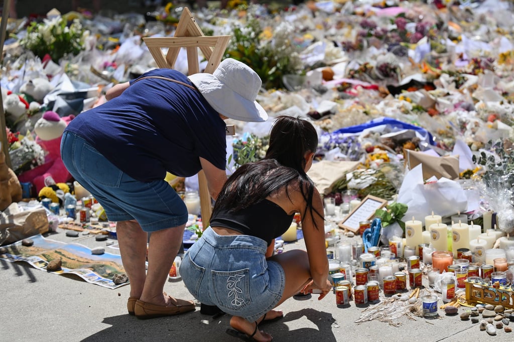 People add to a floral tribute outside Bondi Pavilion at Bondi Beach in Sydney on Thursday. Photo: AP People add to a floral tribute outside Bondi Pavilion at Bondi Beach in Sydney on Thursday. Photo: AP