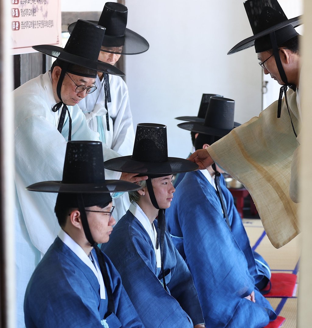 Foreign students receive a “gat”, or traditional Korean hat, during a traditional coming-of-age ceremony at Yeungnam University in Gyeongsan, South Korea, on May 14. Photo: Yonhap/EPA-EFE