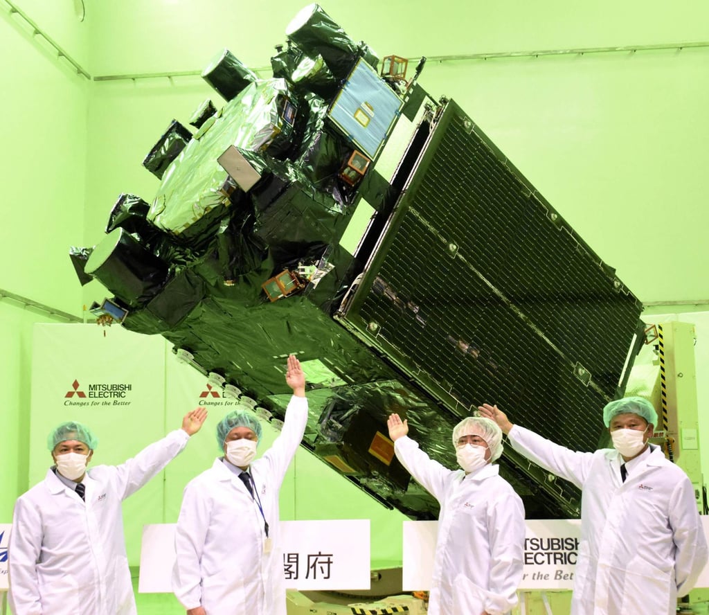 Mitsubishi Electric employees unveil the Michibiki No 7 geolocation satellite on December 1. Photo: Kyodo