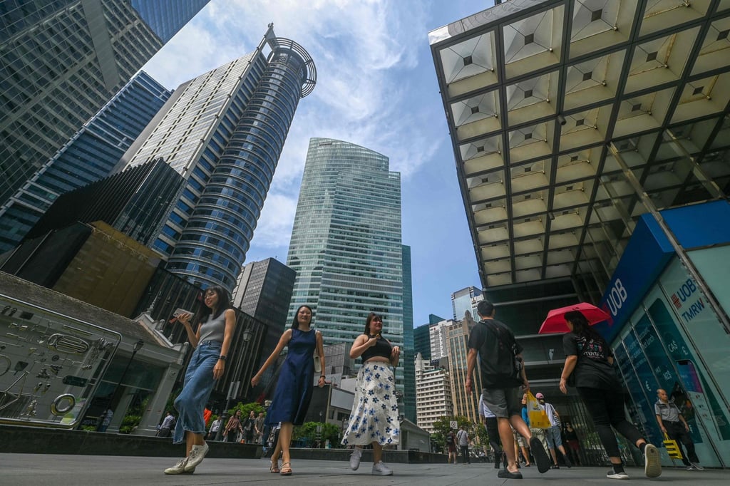 People walk out for a lunch break in the Raffles Place financial business district in Singapore. The city state in October launched the Graduate Industry Traineeships scheme for fresh graduates. Photo: AFP