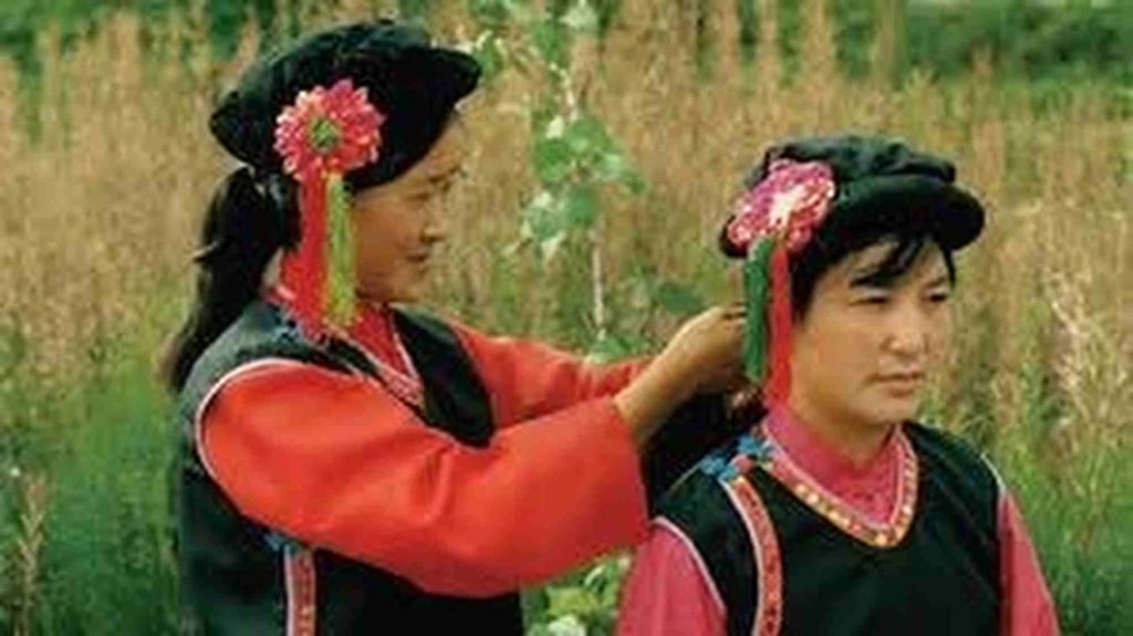 An older woman from the Bao’an ethnic minority fixes the hair of a fellow member of the group. Photo: dzwww.com