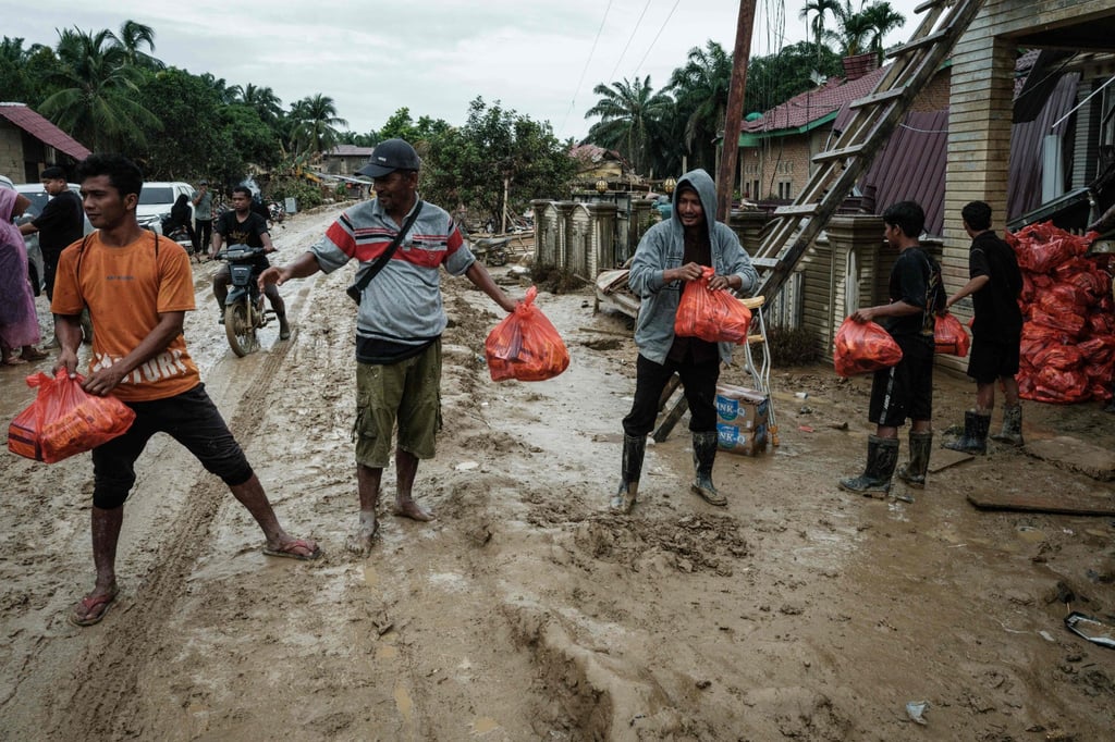 People unload aid supplies for distribution in Aceh Tamiang, Indonesia’s North Sumatra province, on Monday following heavy flooding earlier this month. Photo: AFP