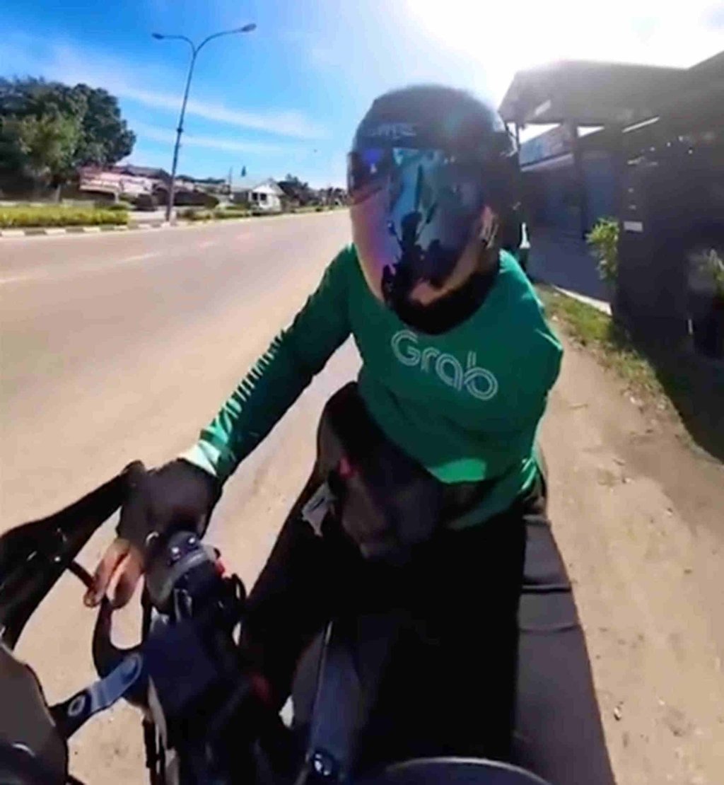 Ahmad Nabil Rosli on his delivery rounds. He carefully manages his motorcycle despite his disability. Photo: 8world.com