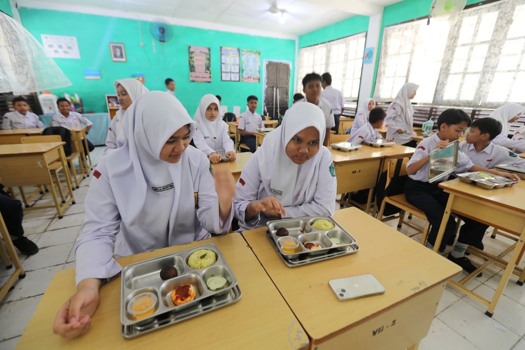 Indonesian students consume their free meals at a junior high school in Banda Aceh, Indonesia, in August. The programme has run into food safety lapses and budget pressures. Photo: EPA