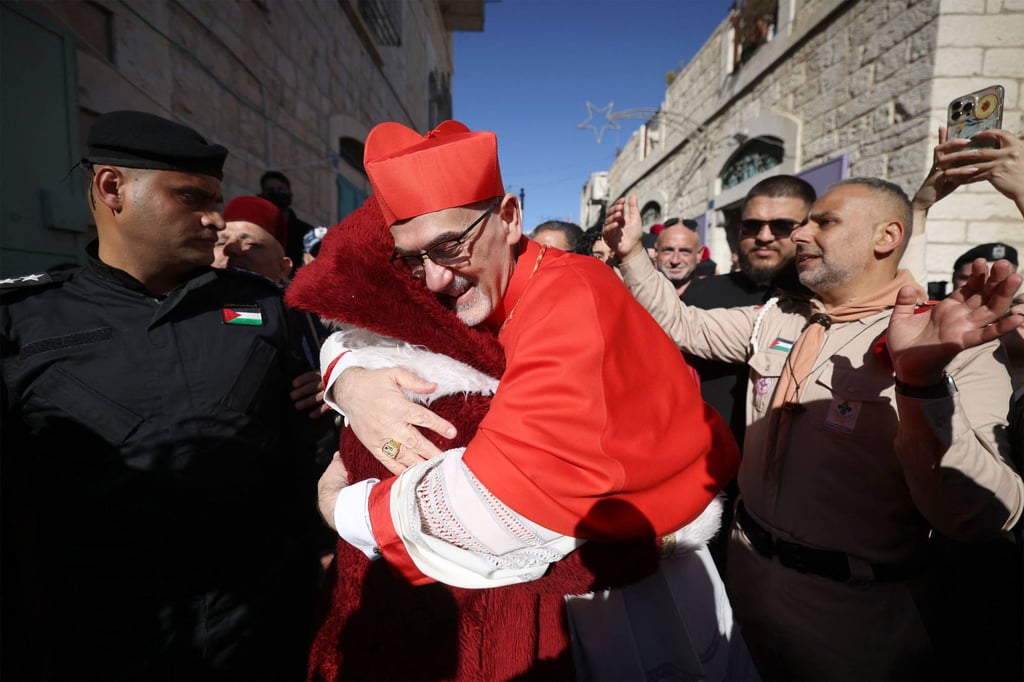 Cardinal Pierbattista Pizzaballa hugs a man dressed up as Santa Claus as he is welcomed in Bethlehem on Wednesday. Photo: AFP