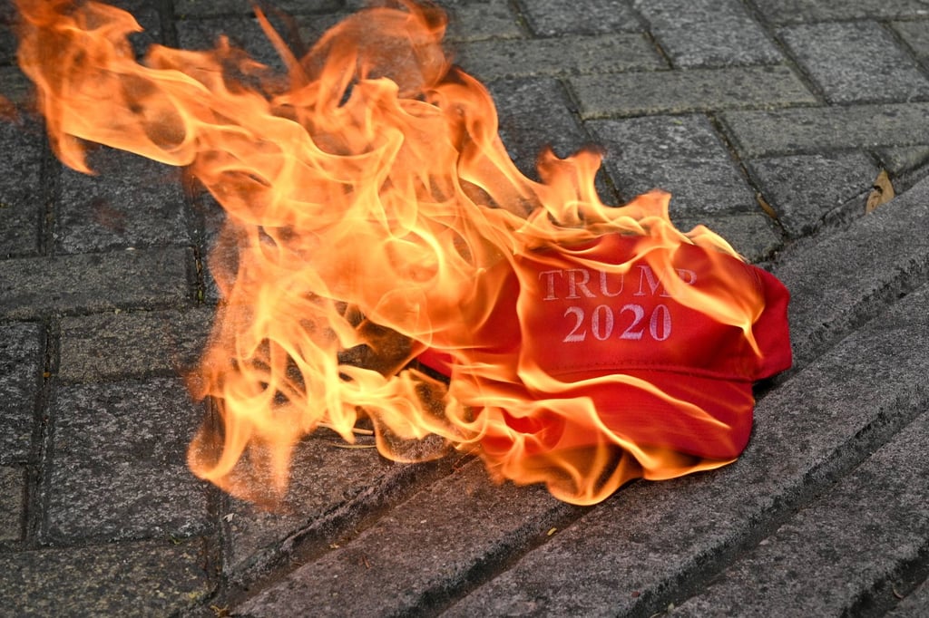 A cap that reads “Trump 2020” burns during a protest outside the US embassy in Tegucigalpa on Tuesday. Photo: AFP