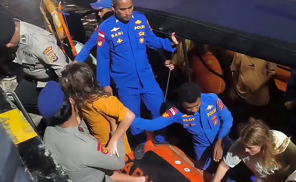 Foreign tourists are helped ashore after being rescued in the waters near Labuan Bajo on Saturday. Photo: Basarnas/AFP