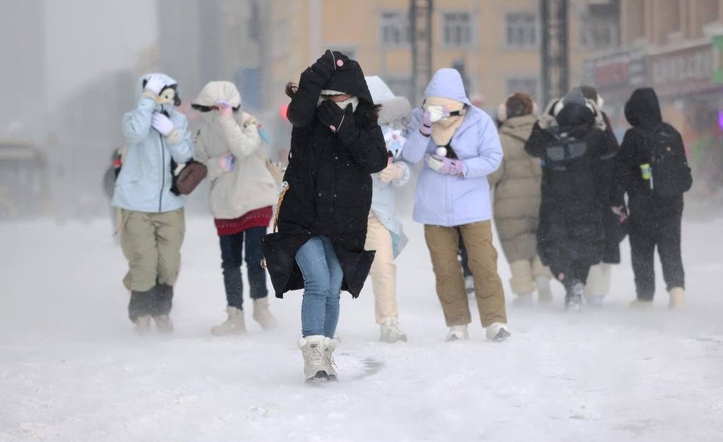 A number of people travelled through traffic jams caused by the snowy weather in Harbin, above. Photo: Xinhua