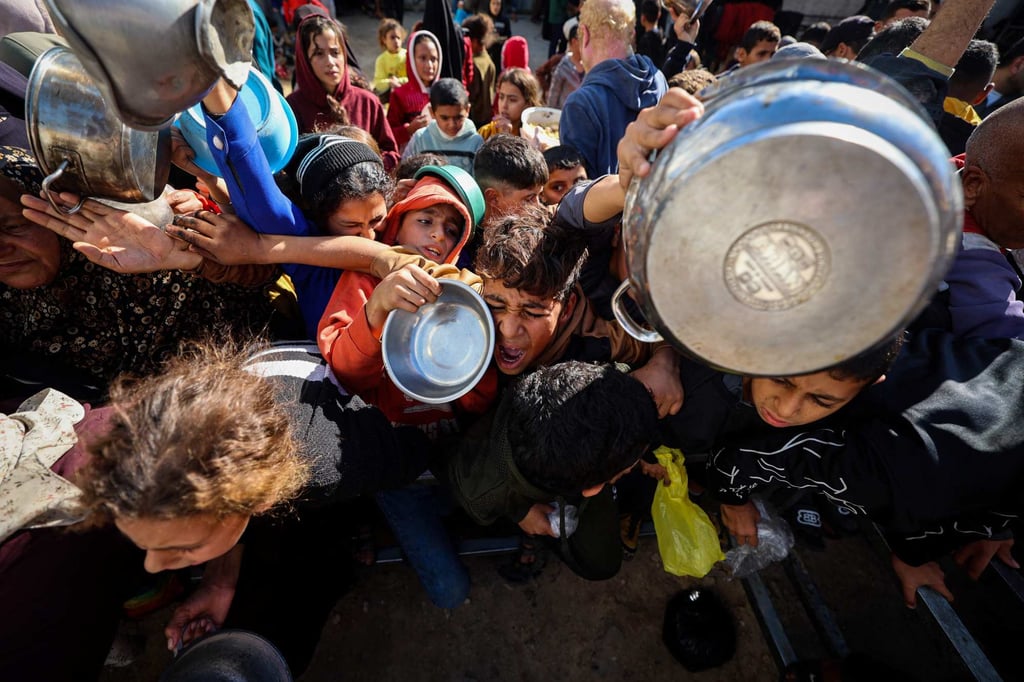 A boy reacts as displaced Palestinians gather for food at a charity kitchen in central Gaza on December 20. Israel says it is meeting ceasefire aid commitments, but humanitarian groups disagree and urge more aid. Photo: AFP A boy reacts as displaced Palestinians gather for food at a charity kitchen in central Gaza on December 20. Israel says it is meeting ceasefire aid commitments, but humanitarian groups disagree and urge more aid. Photo: AFP