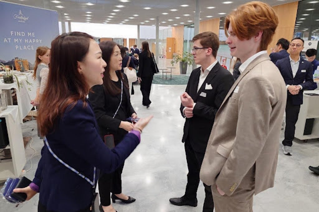 Winnie Lai (left), director of human resources at Hyatt Regency Hong Kong, Tsim Sha Tsui, speaks with visitors at a career fair in Switzerland.