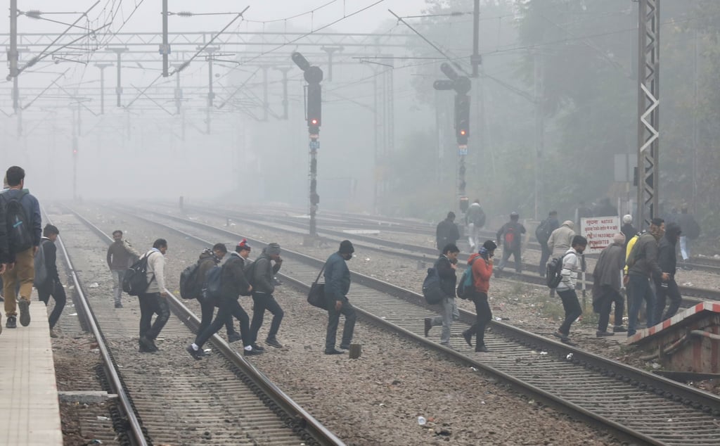 People walk on a railway track amid heavy smog on a winter morning in New Delhi on December 18. The winter smog is driving more patients with respiratory complaints to hospitals. Photo: EPA People walk on a railway track amid heavy smog on a winter morning in New Delhi on December 18. The winter smog is driving more patients with respiratory complaints to hospitals. Photo: EPA