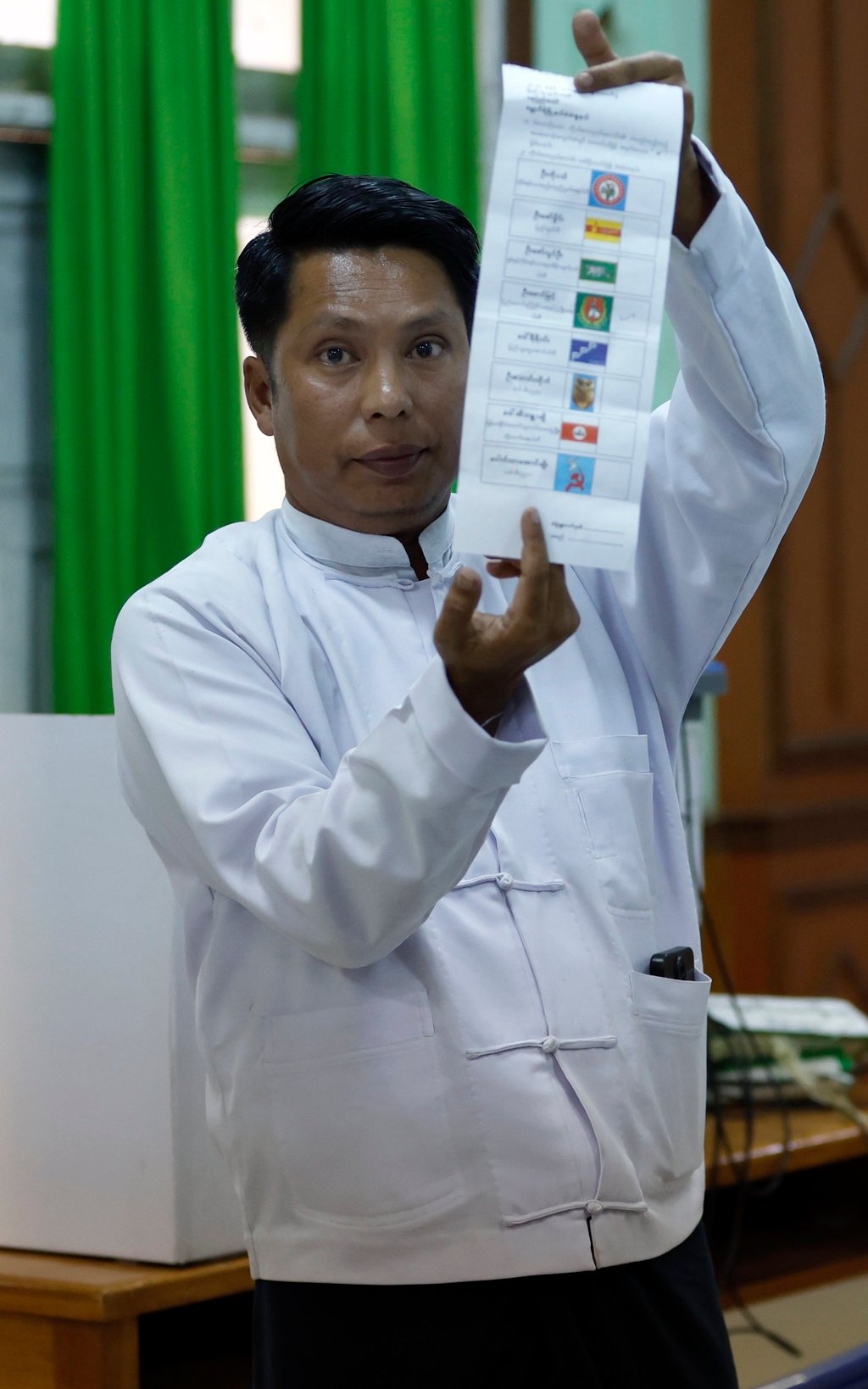 A Myanmese electoral officer holds up a ballot paper during a count in Naypyidaw on December 28. Photo: EPA