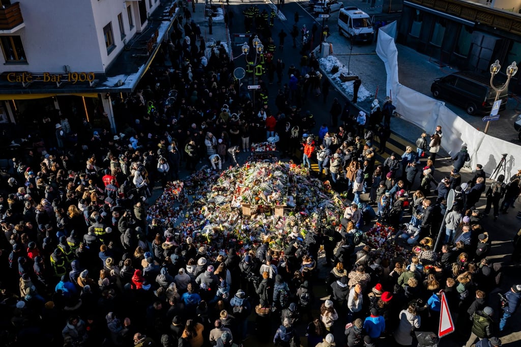 Mourners gather around flowers in Crans-Montana. Photo: EPA