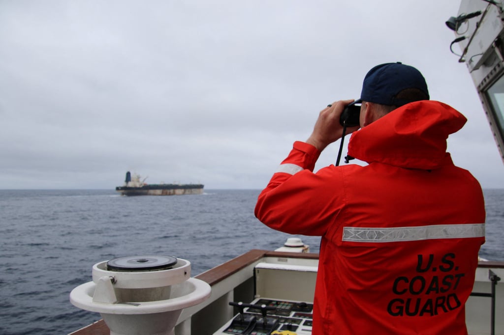 A US Coast Guard official looks through binoculars at the Russian-linked Bella 1 tanker, which had been renamed Marinera. Photo: US European Command via Reuters