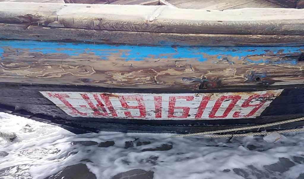 Numbers and letters are seen on a wooden boat containing human remains and suspected to be from North Korea along a shoreline of Sado island on December 28, 2019. Photo: Sado Coast Guard Station/Reuters