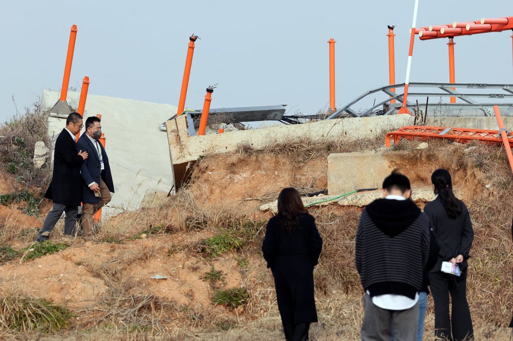 Bereaved family members walk near a concrete structure at the site of the Jeju Air crash at Muan International Airport on December 29, 2025. Photo: Reuters