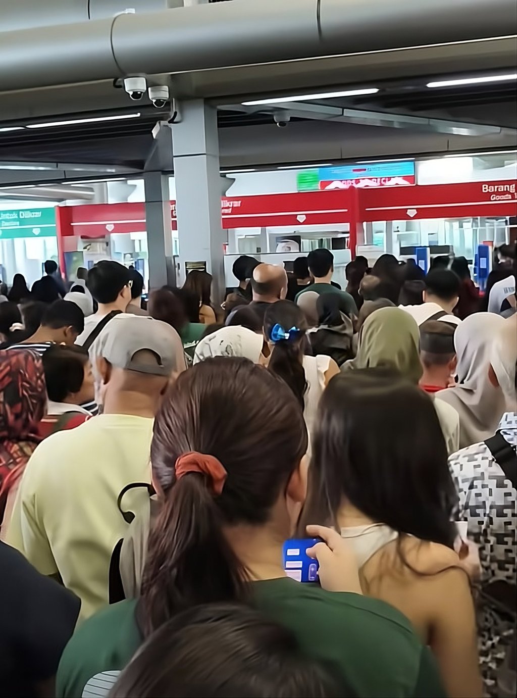 A screengrab taken from a social media video circulated on Saturday shows a crowd of travellers waiting to pass through automated immigration gates at the Malaysia-Singapore border. Photo: Facebook