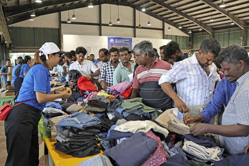People pick up free clothing at a thank-you event for migrant construction workers in Singapore on November 30, 2025. Foreign workers account for about 40 per cent of the city state’s total population. Photo: Kyodo