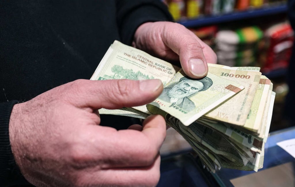 A shop owner counts Iranian banknotes at a store in the capital Tehran on Wednesday. Photo: AFP