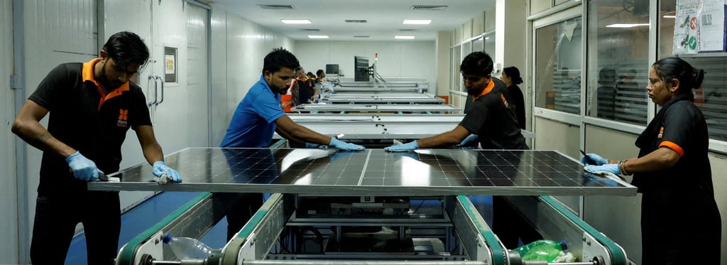Technicians work on a solar panel in Greater Noida, on the outskirts of New Delhi. Photo: Reuters