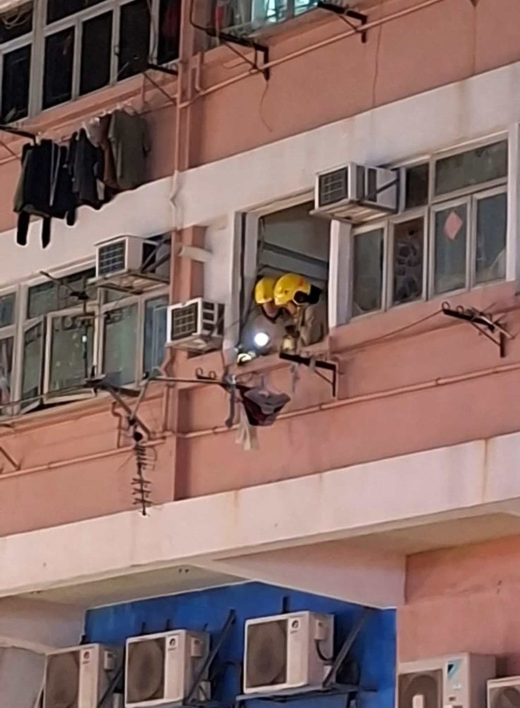 Firefighters inspect the first-floor flat at 43 Pak Tai Street, where the blast occurred. Photo: Handout