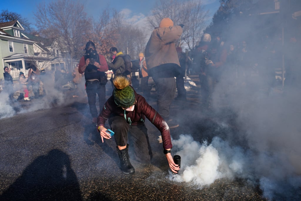 A protester covers a tear-gas canister deployed by federal immigration officers in Minneapolis on Tuesday. Photo: AP