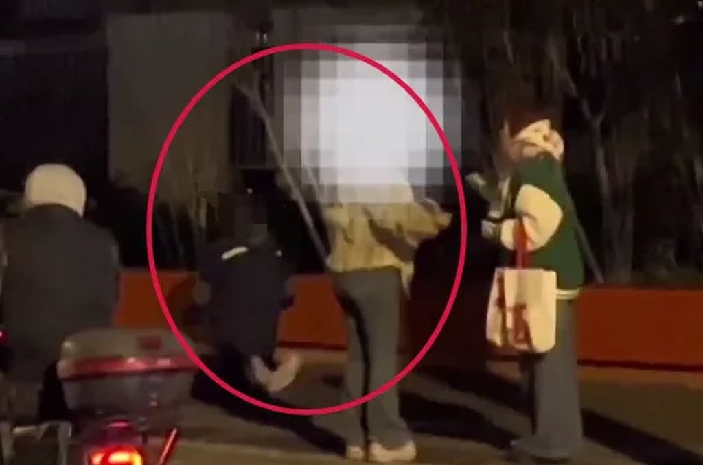 Images posted online show the woman talking with a passer-by and her daughter on her knees. Photo: QQ.com