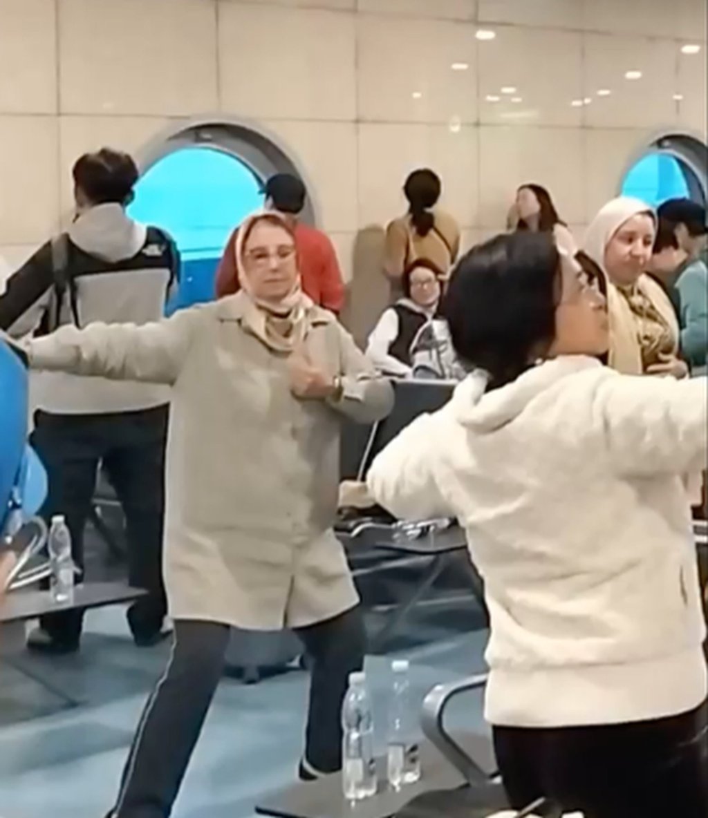 Chinese and foreign passengers spread their arms as they dance inside Cairo Airport. Photo: 8world Chinese and foreign passengers spread their arms as they dance inside Cairo Airport. Photo: 8world