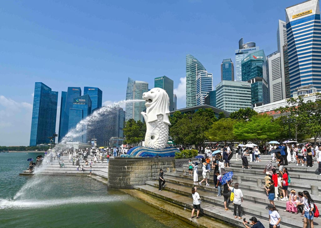 People take pictures next to the Merlion statue at the Marina Bay waterfront in Singapore on July 30 last year. Photo: AFP