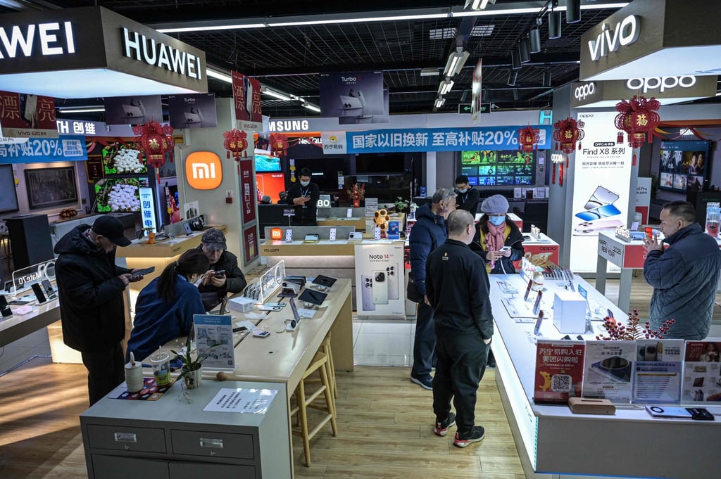 Customers shop for smartphones at an electronics store in Beijing. Photo: AFP