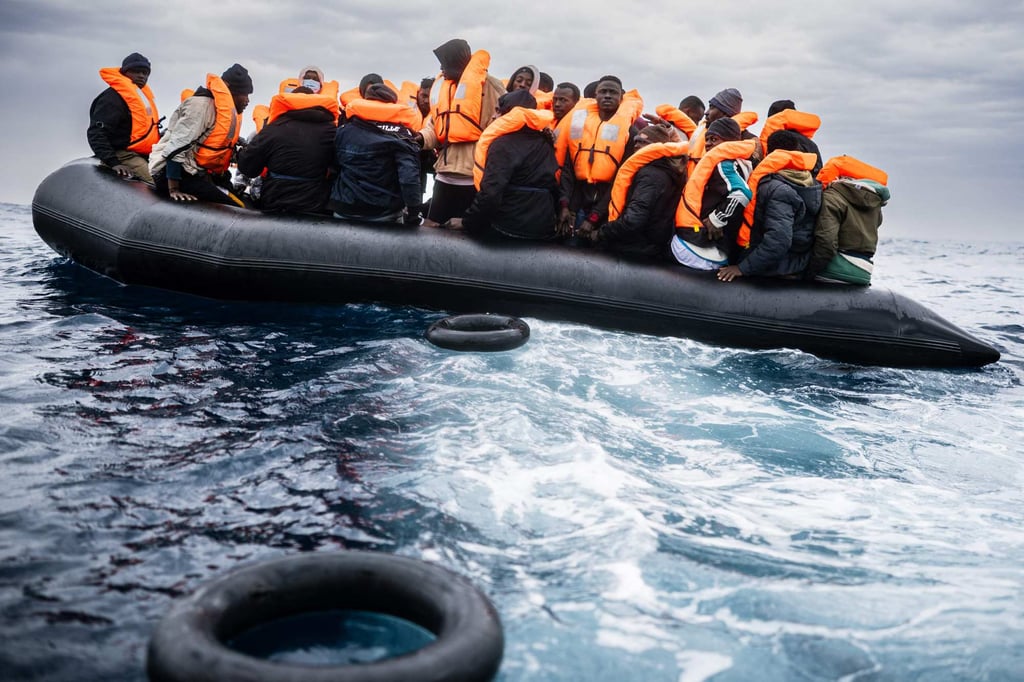 Migrants on a rubber boat prepare to be rescued. Photo: AFP