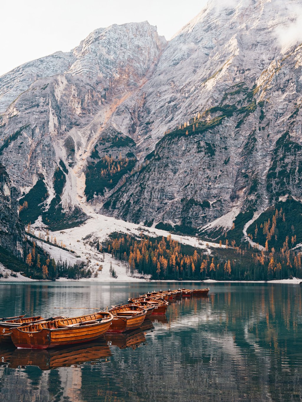 Wooden rowing boats rest in a line on Lago di Braies, a famous spot in the Dolomites for boating. Photo: Handout