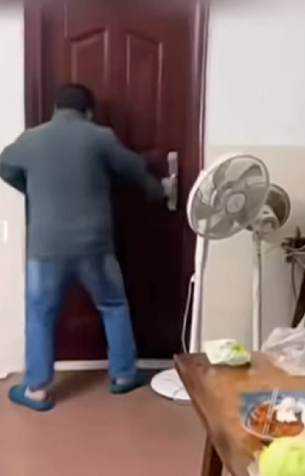 The enraged father rants outside his daughter’s bedroom door as she hides inside. Photo: The Paper The enraged father rants outside his daughter’s bedroom door as she hides inside. Photo: The Paper