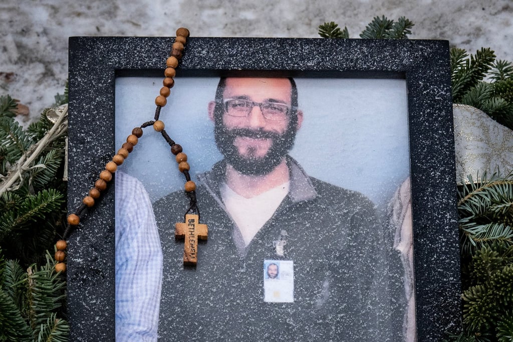 A rosary hangs on a framed photo of Alex Pretti at a January 25 memorial near where he was fatally shot by federal immigration agents the day before. Photo: TNS