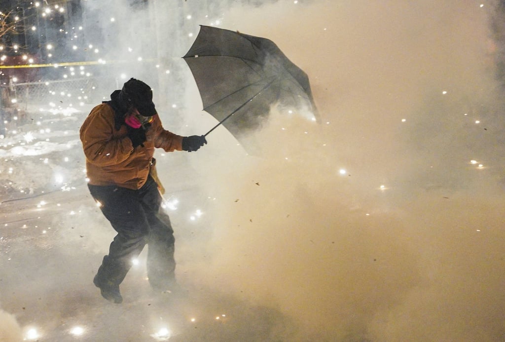 A protester attempts to protect themselves as federal agents fire munitions and pepper balls in Minneapolis, Minnesota, on January 14. Photo: Reuters A protester attempts to protect themselves as federal agents fire munitions and pepper balls in Minneapolis, Minnesota, on January 14. Photo: Reuters