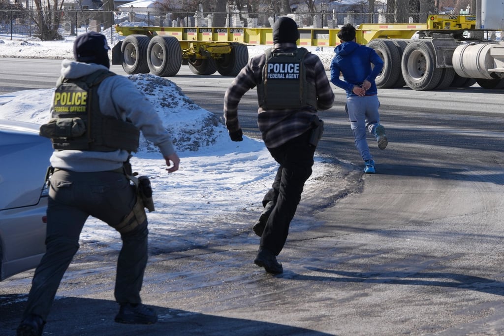 A man in handcuffs runs from federal immigration agents in Minneapolis. Photo: AP A man in handcuffs runs from federal immigration agents in Minneapolis. Photo: AP