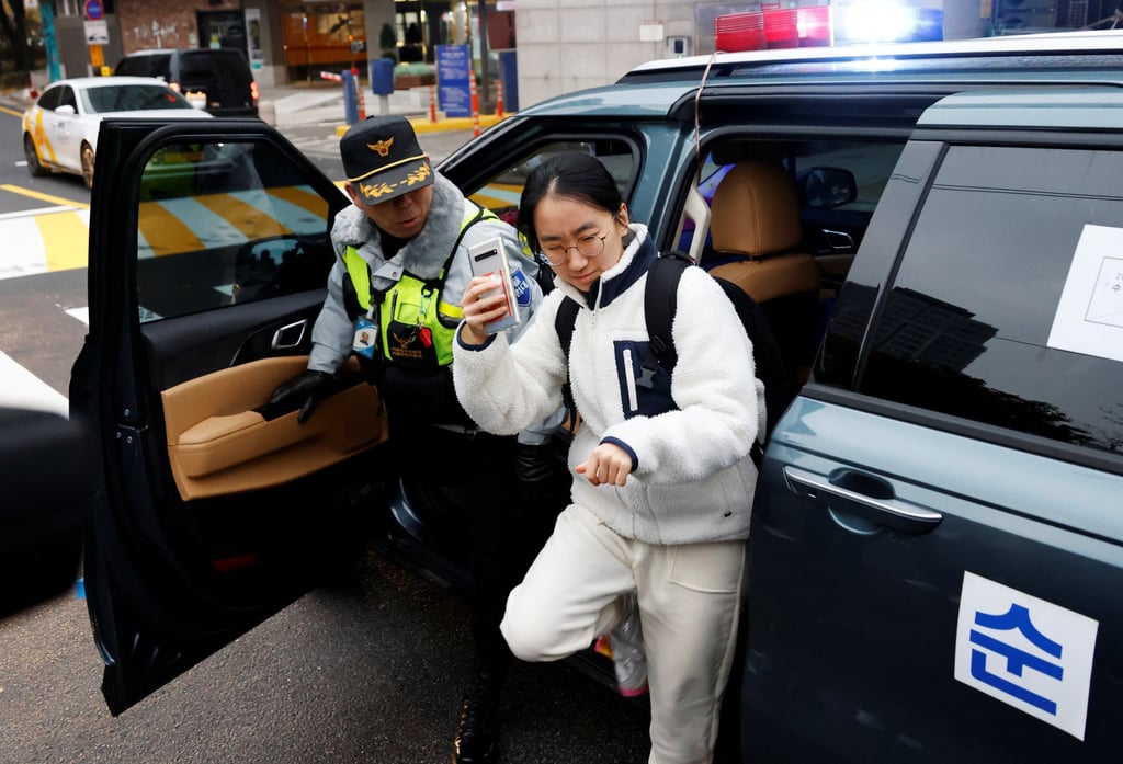 Police escort a student taking the College Scholastic Ability Test to school in Seoul. Photo: Reuters
