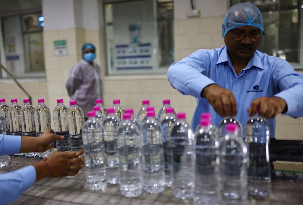 Workers arrange bottles filled with natural water on a conveyor at Tata’s bottling plant in Himachal Pradesh on October 16. Photo: Reuters