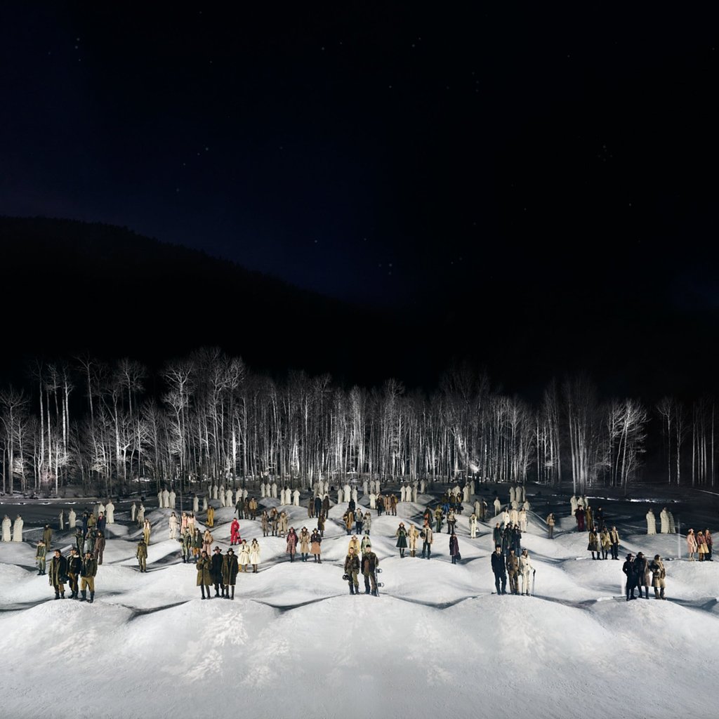 Models walked down a sloping snow-covered runway surrounded by trees. Photo: Handout