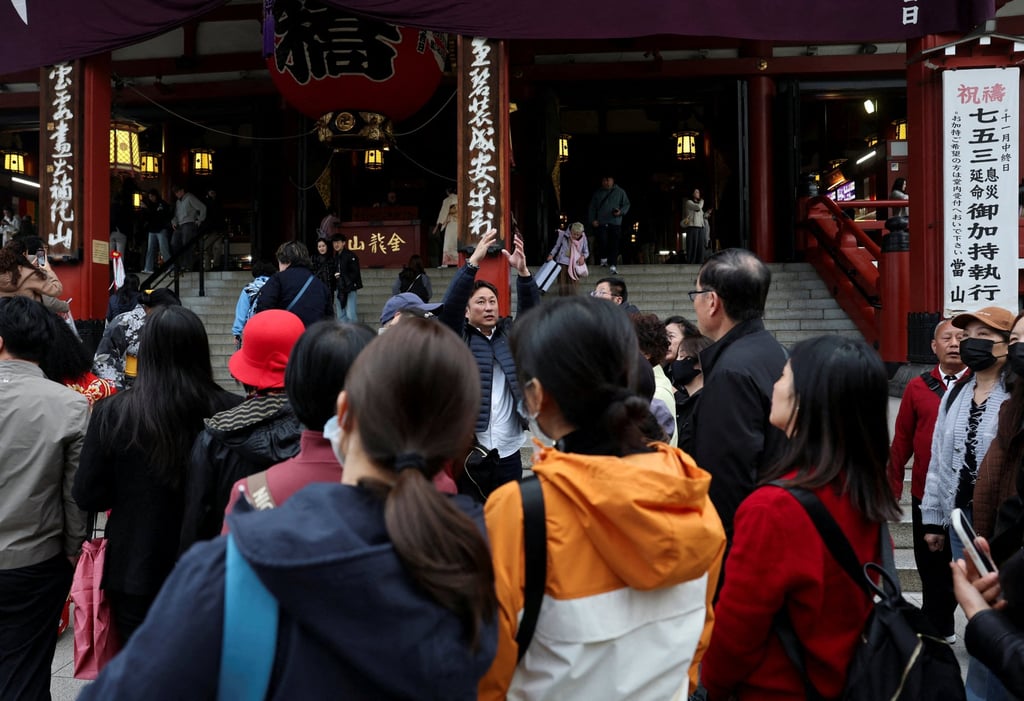A Chinese tourist group is led by a tour guide in Asakusa, a popular sightseeing spot in Tokyo, Japan, in November 2025. Photo: Reuters
