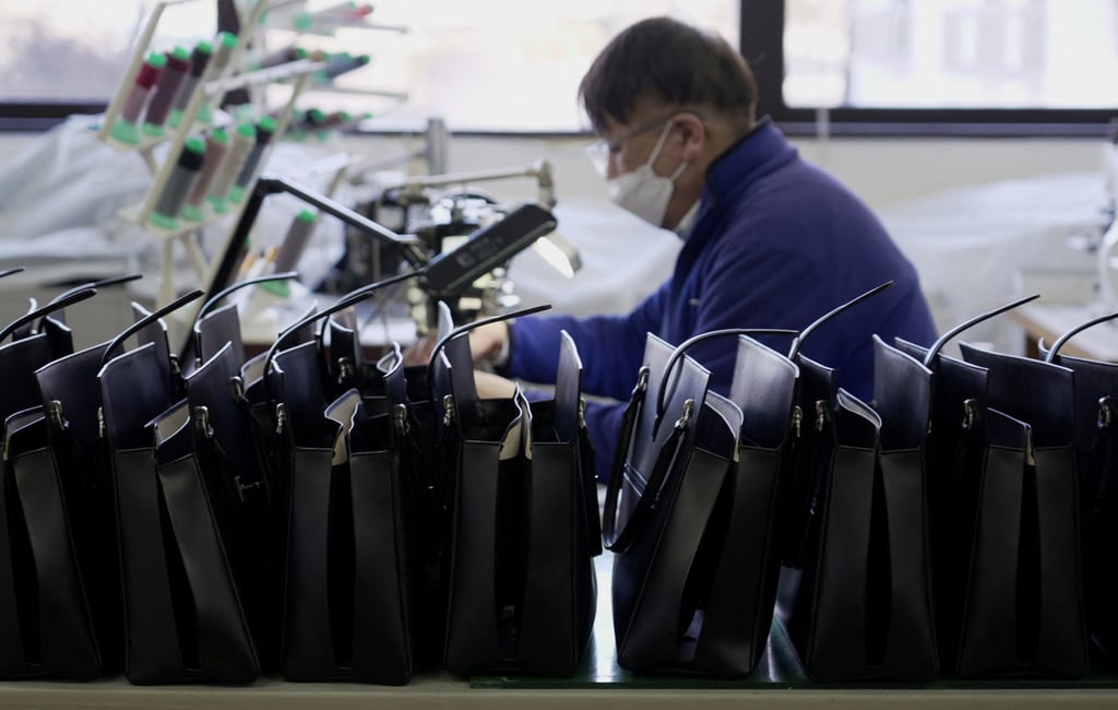 A worker stitches a leather bag at the Hamano factory in Miyota on Monday. Photo: Reuters A worker stitches a leather bag at the Hamano factory in Miyota on Monday. Photo: Reuters