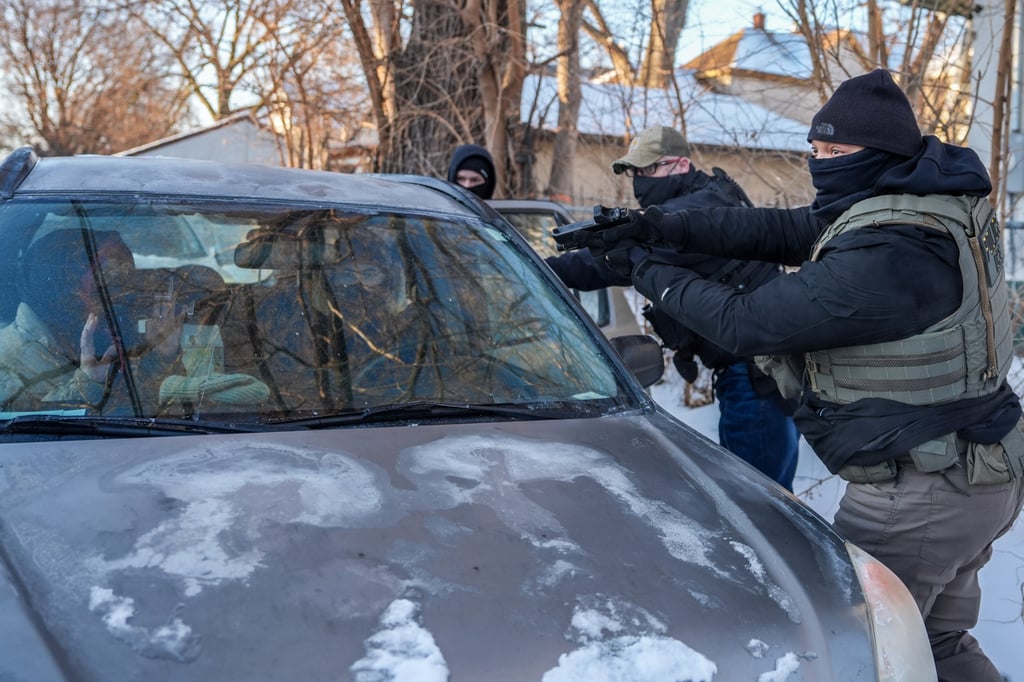 Activists are approached by a federal agent brandishing a firearm, for following agents’ vehicles in Minneapolis. Photo: AP Activists are approached by a federal agent brandishing a firearm, for following agents’ vehicles in Minneapolis. Photo: AP