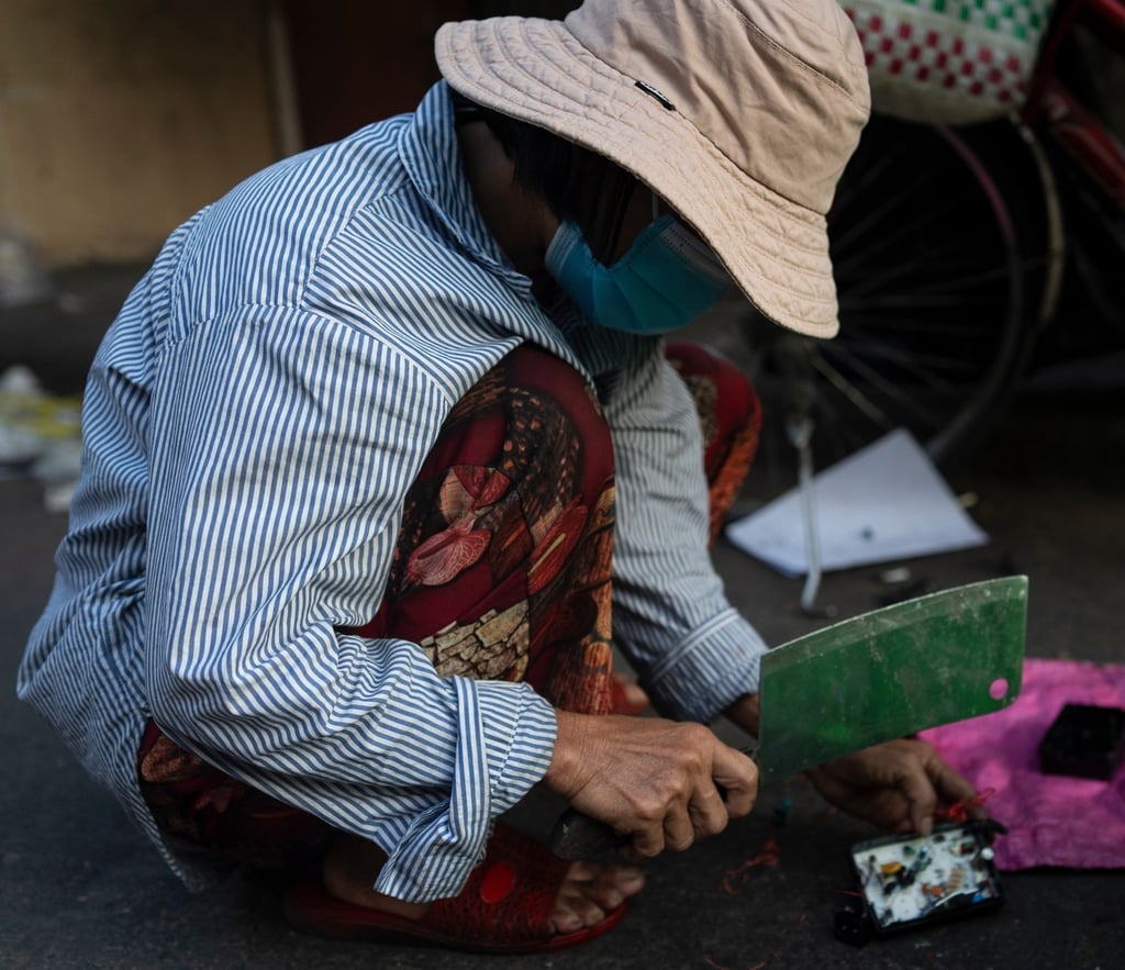 An e-waste collector uses a cleaver to remove copper wire from a device in Vietnam’s Nhat Tao market. Photo: AP An e-waste collector uses a cleaver to remove copper wire from a device in Vietnam’s Nhat Tao market. Photo: AP