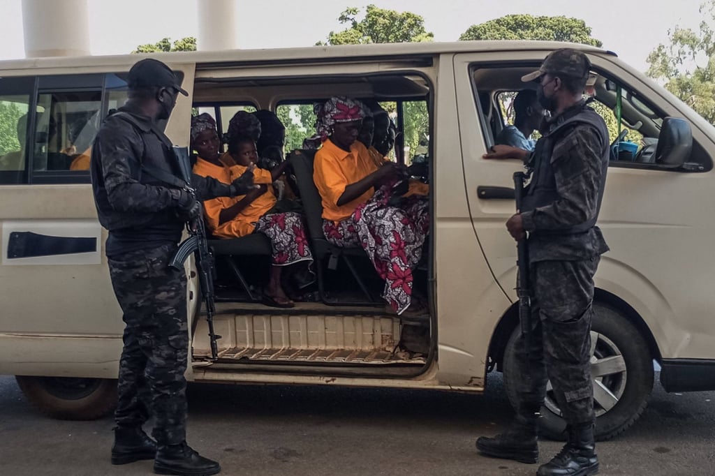 Security officers stand guard next to a bus of freed worshippers. Photo: AFP
